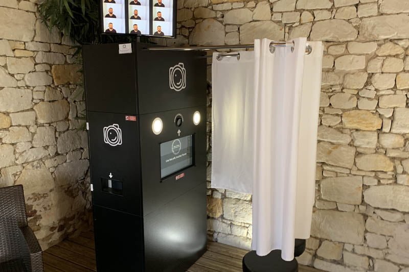 La cabine photobooth avec rideau et tabourets du Kiosque à Sourires