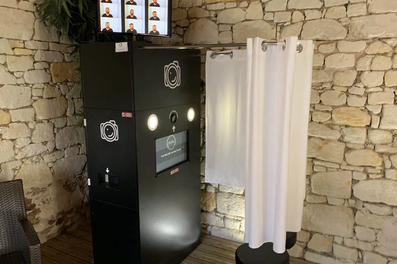 La cabine photobooth avec rideau et tabourets du Kiosque à Sourires