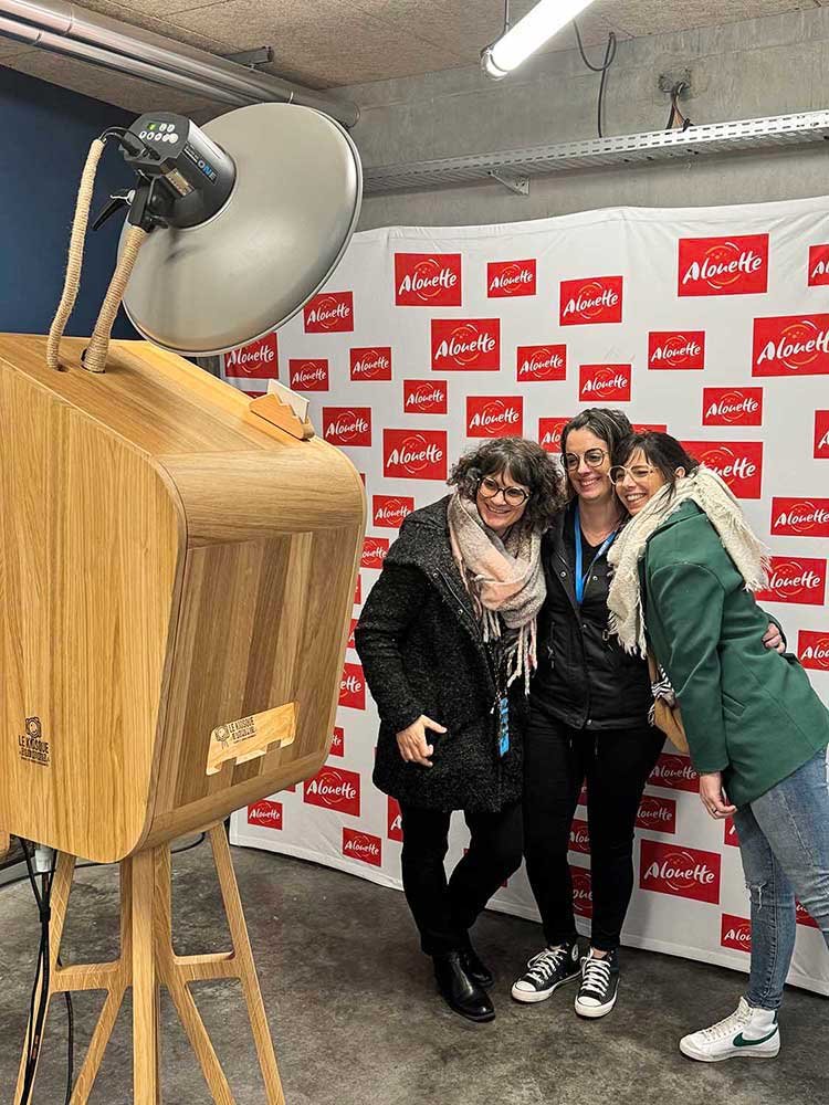 Invités utilisant une borne photobooth en bois